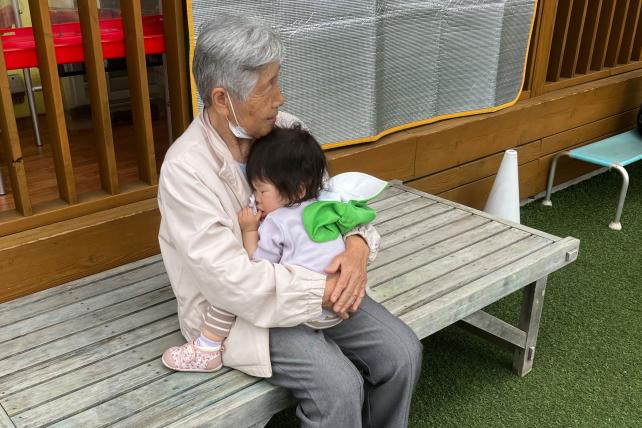 Japan child sleeping in older person's arms