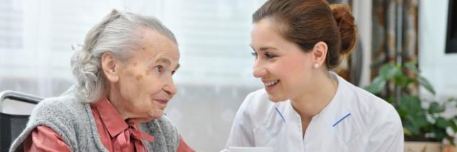 Elderly woman and carer having tea