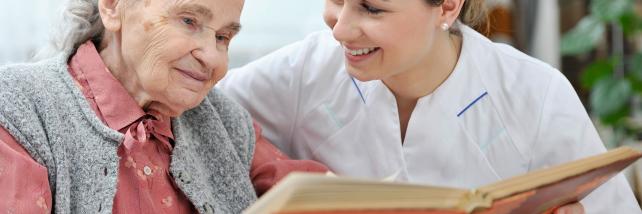 Elderly woman and carer reading